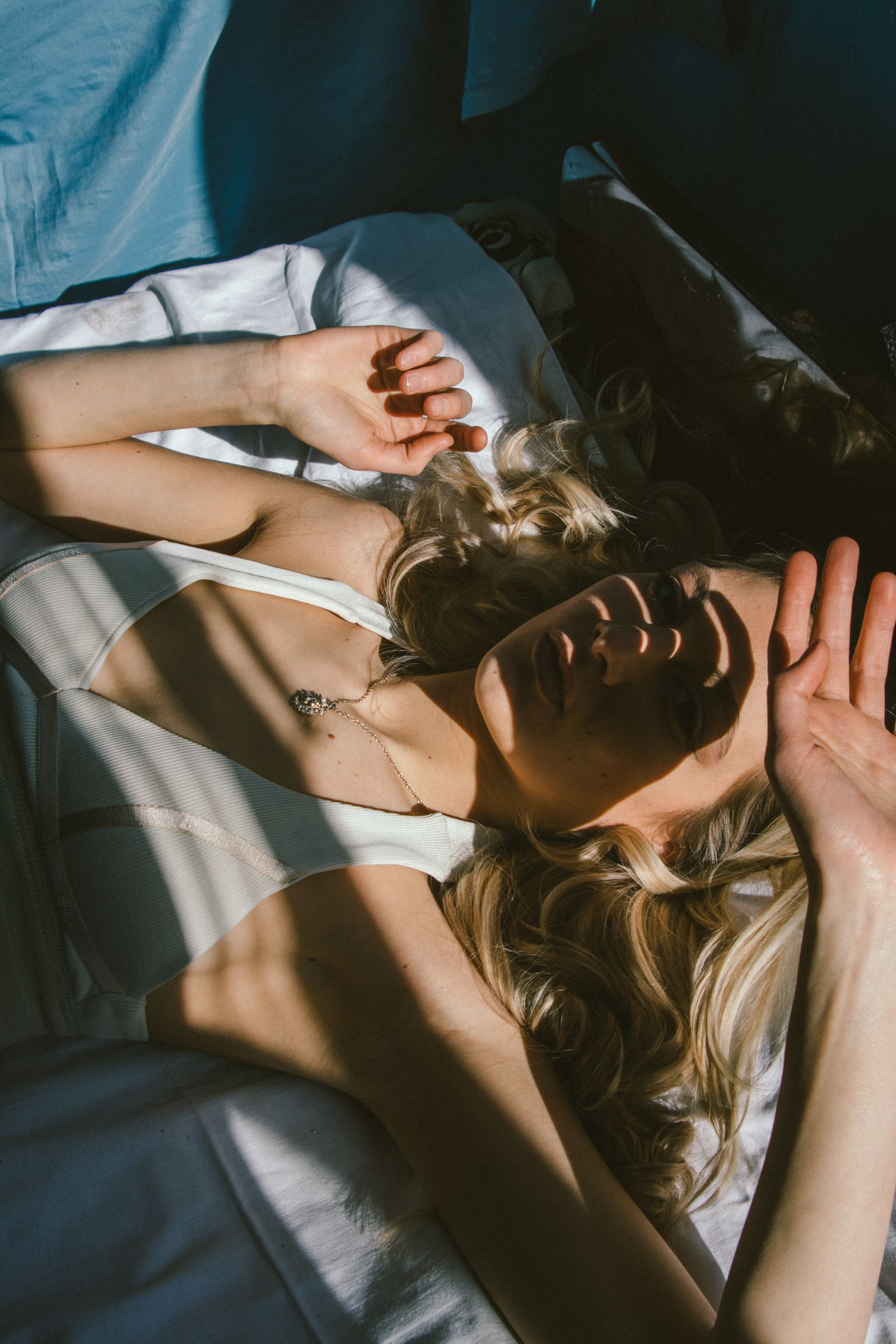 Woman reclining in sunlight with shadows across her face